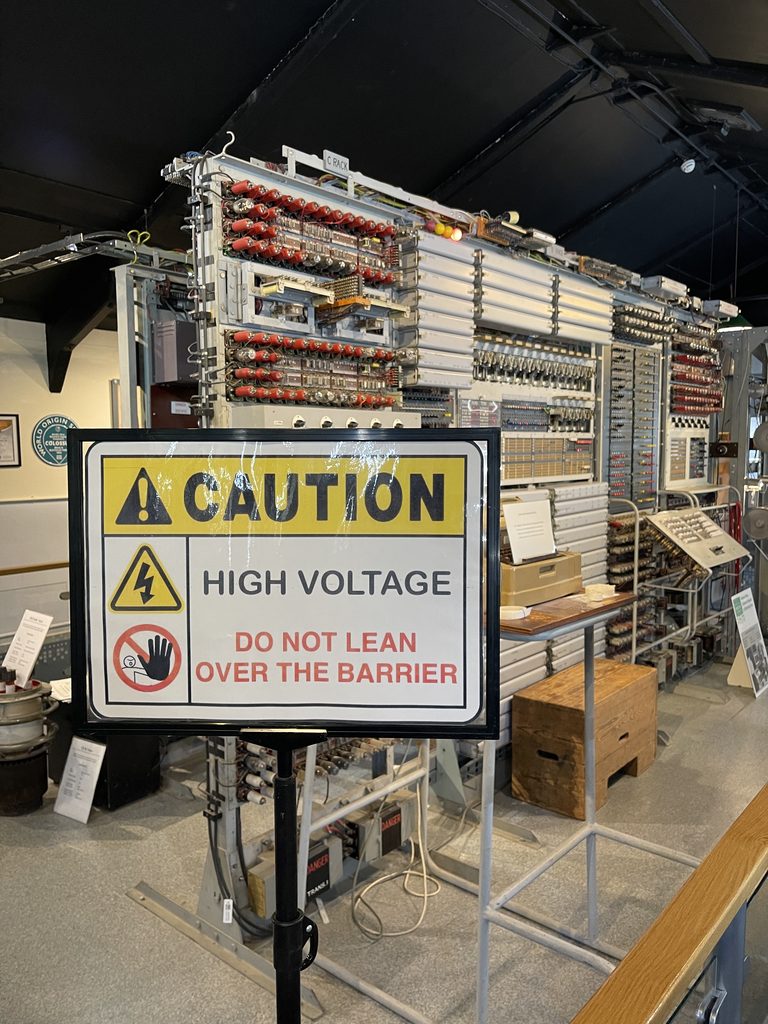 Colossus racks behind a high voltage warning sign