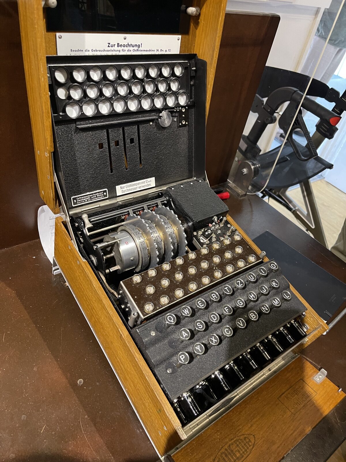 A German Enigma cipher machine open in its wooden case