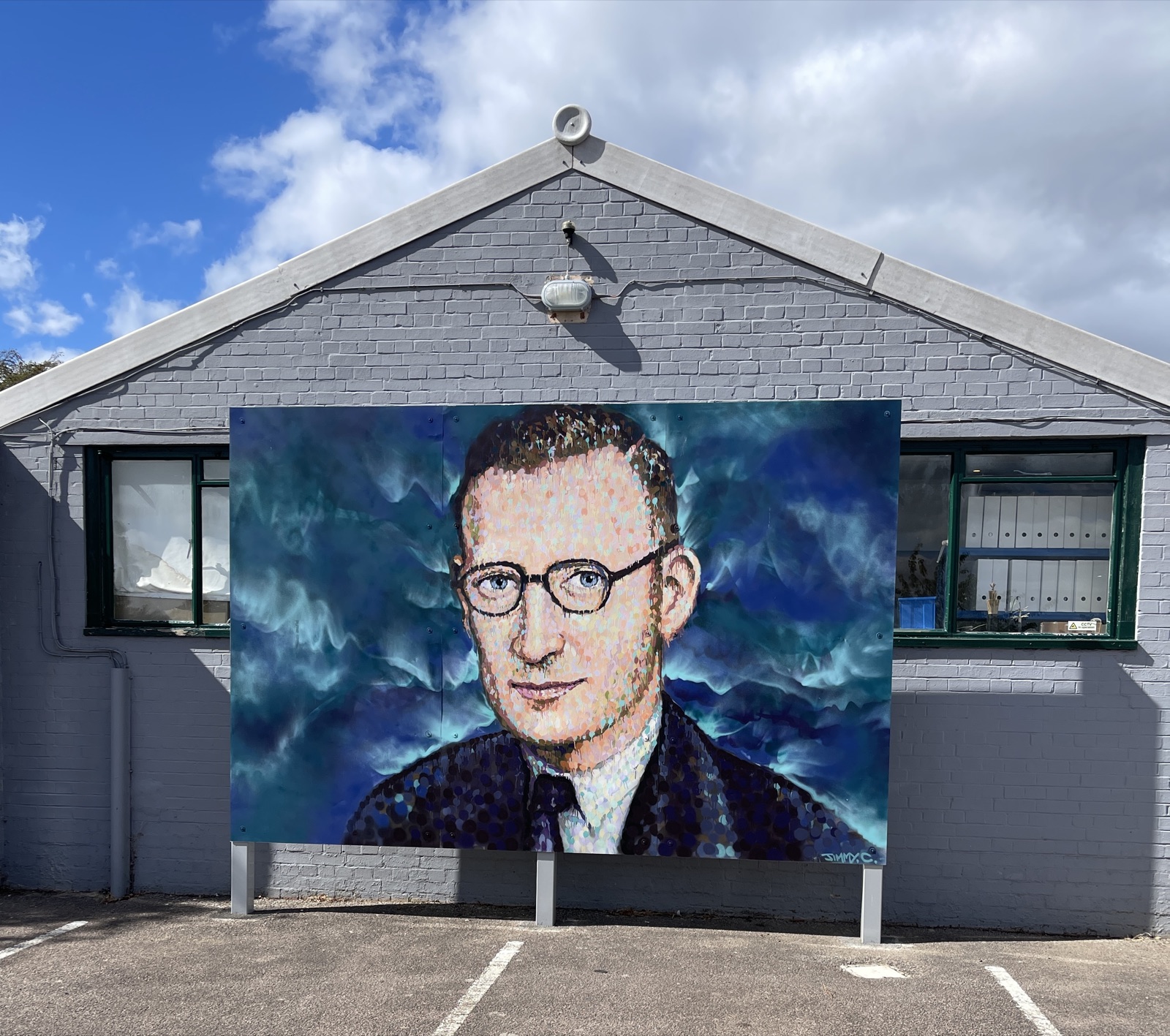 Jimmy C's pointillist mural of Tommy Flowers on the gable end of The National Museum of Computing at Bletchley Park